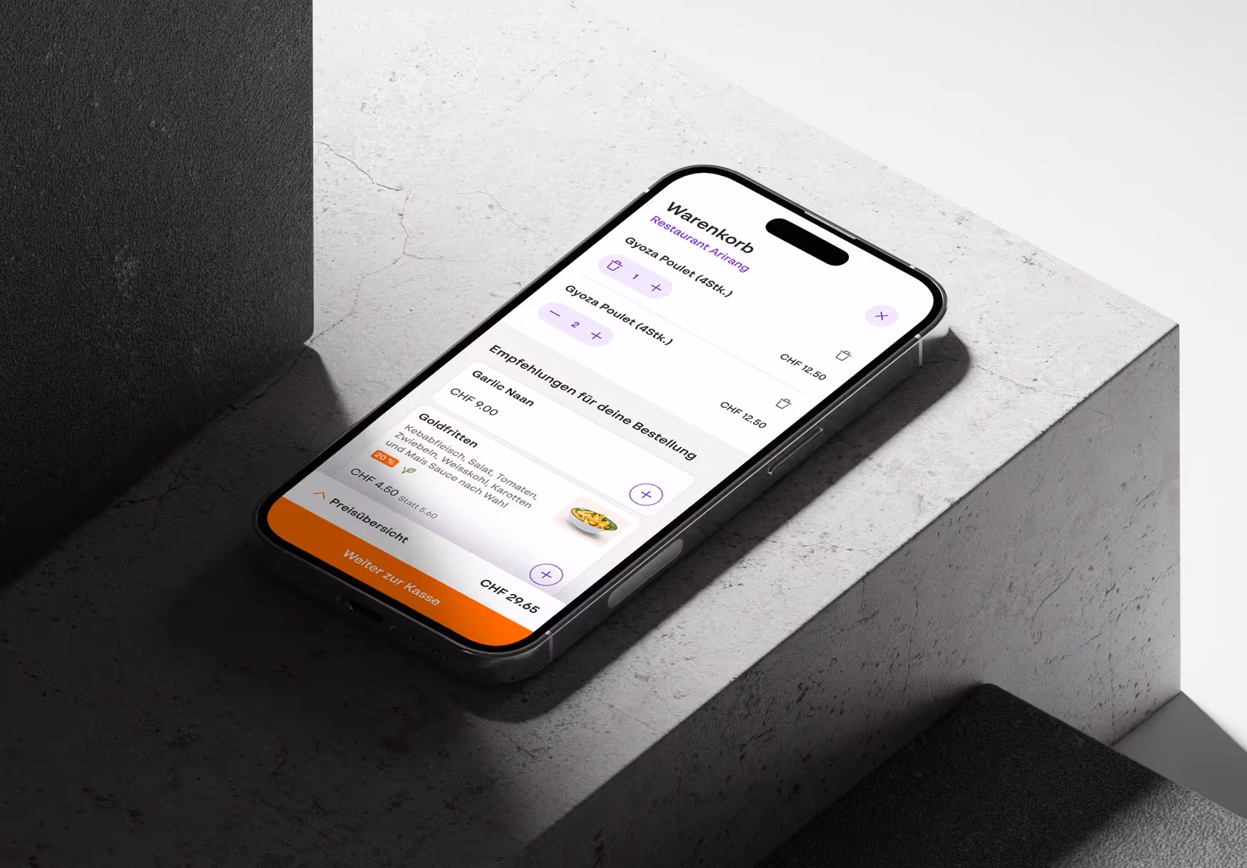 Smartphone showing a food delivery app checkout screen with items Gyoza Poulet and upsell recommendations including Garlic Naan and Goldfritten.