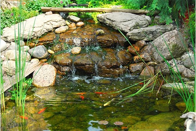 Small waterfall tumbling into a backyard water feature
