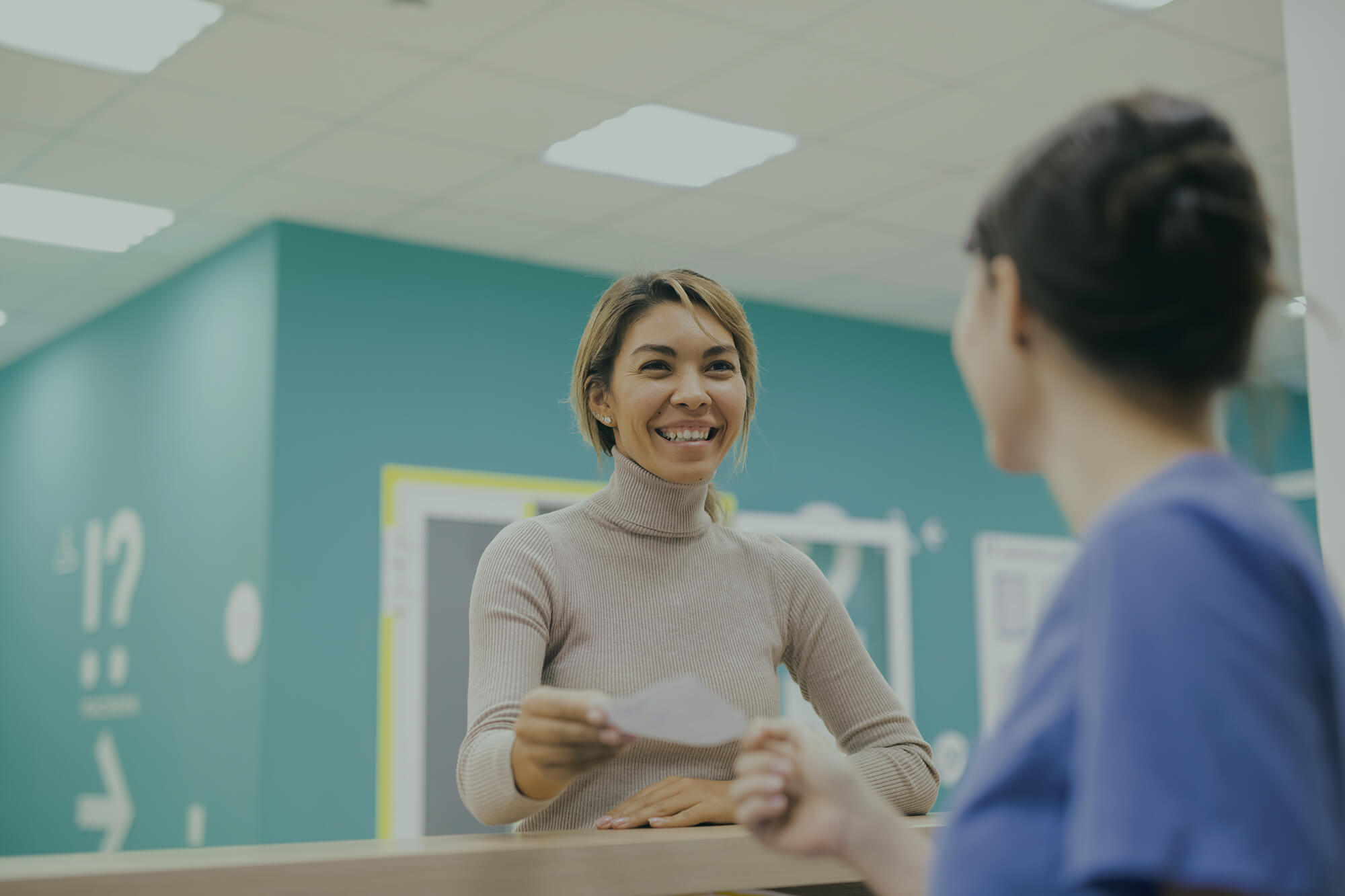 Patiënt die vriendelijk wordt ontvangen in de praktijk.