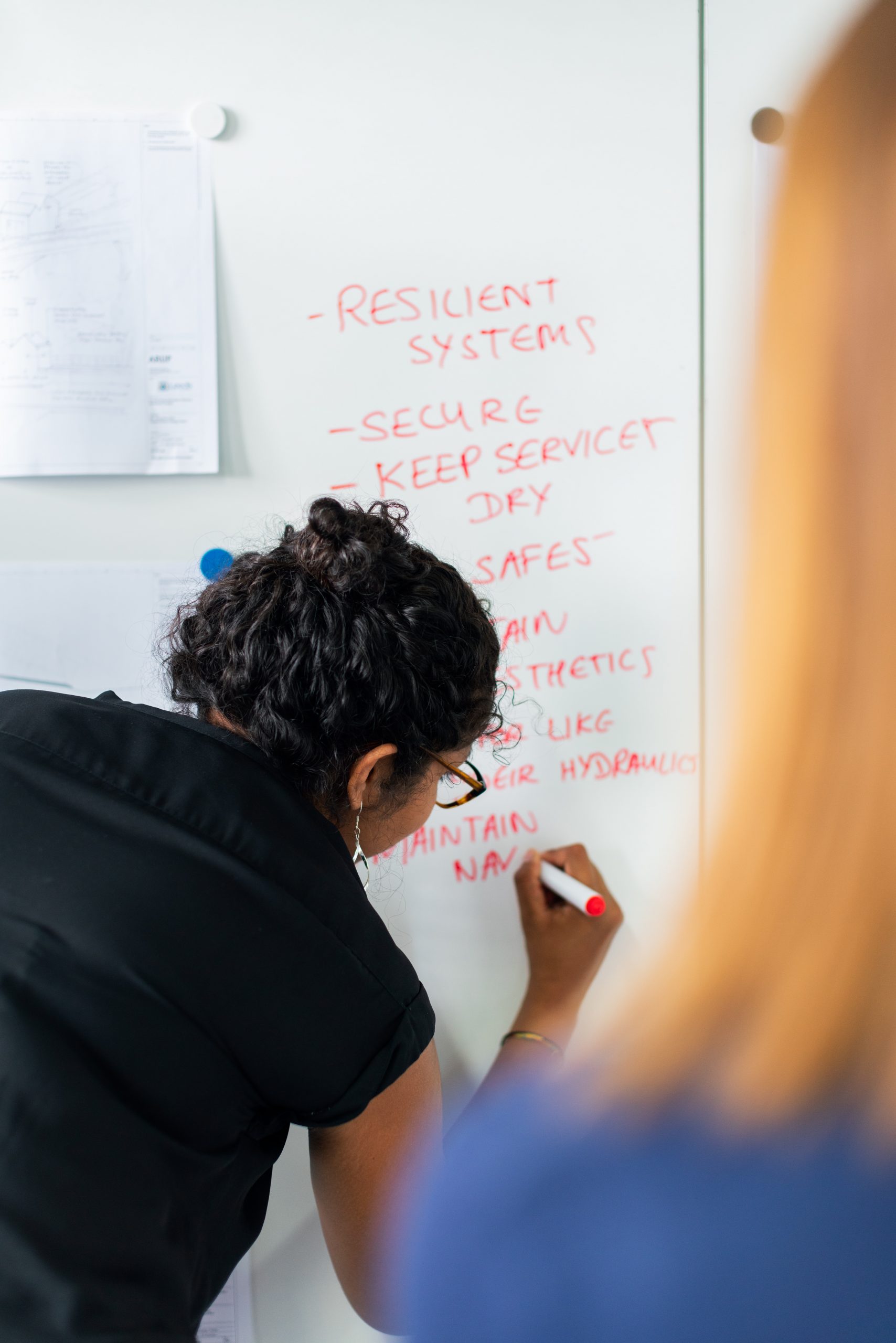 woman writing on a dry erase board