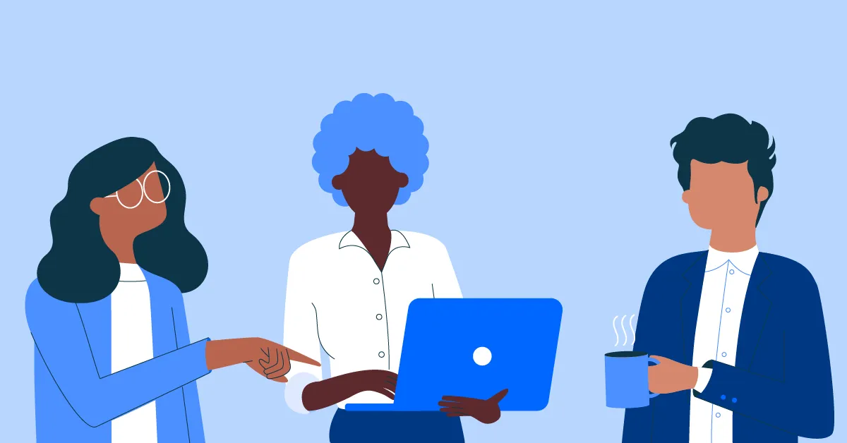 Three diverse people in discussion; one pointing at a laptop, another holding the laptop, and the third holding a steaming cup.