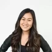 Smiling woman with long dark hair wearing a black jacket and top against a white background.