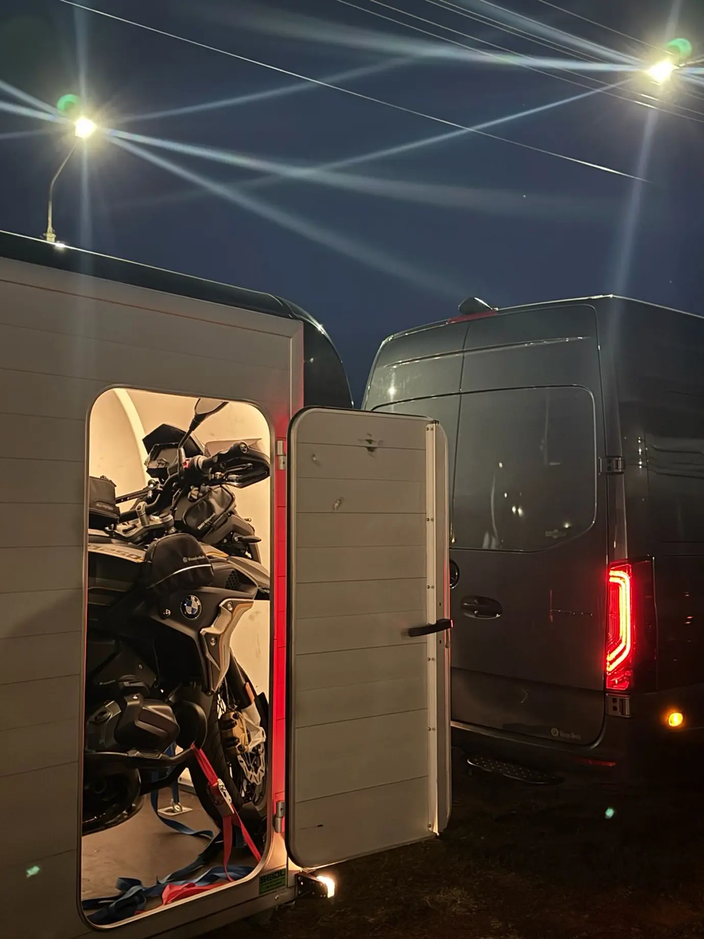 A fedett utánfutó nyitott ajtójánál látható egy biztonságosan rögzített motor. 