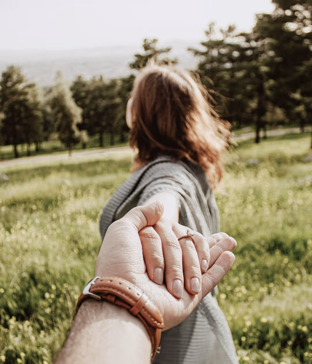 A man holding hand of a woman while she looks away from the camera