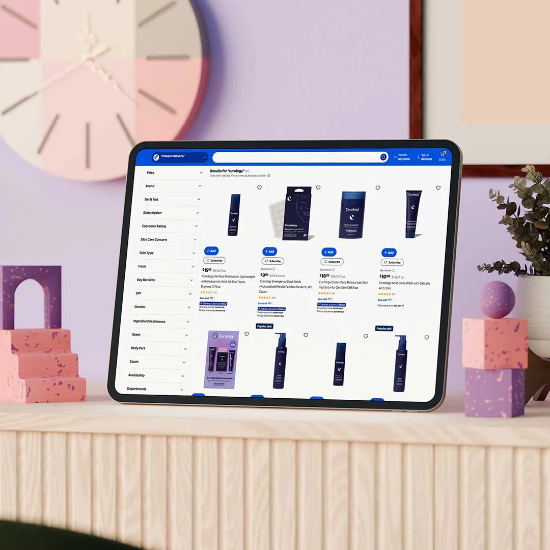 Tablet on a wooden surface displaying an online store page with various skincare products and filters, with a modern room background including a colorful clock and decorative blocks.