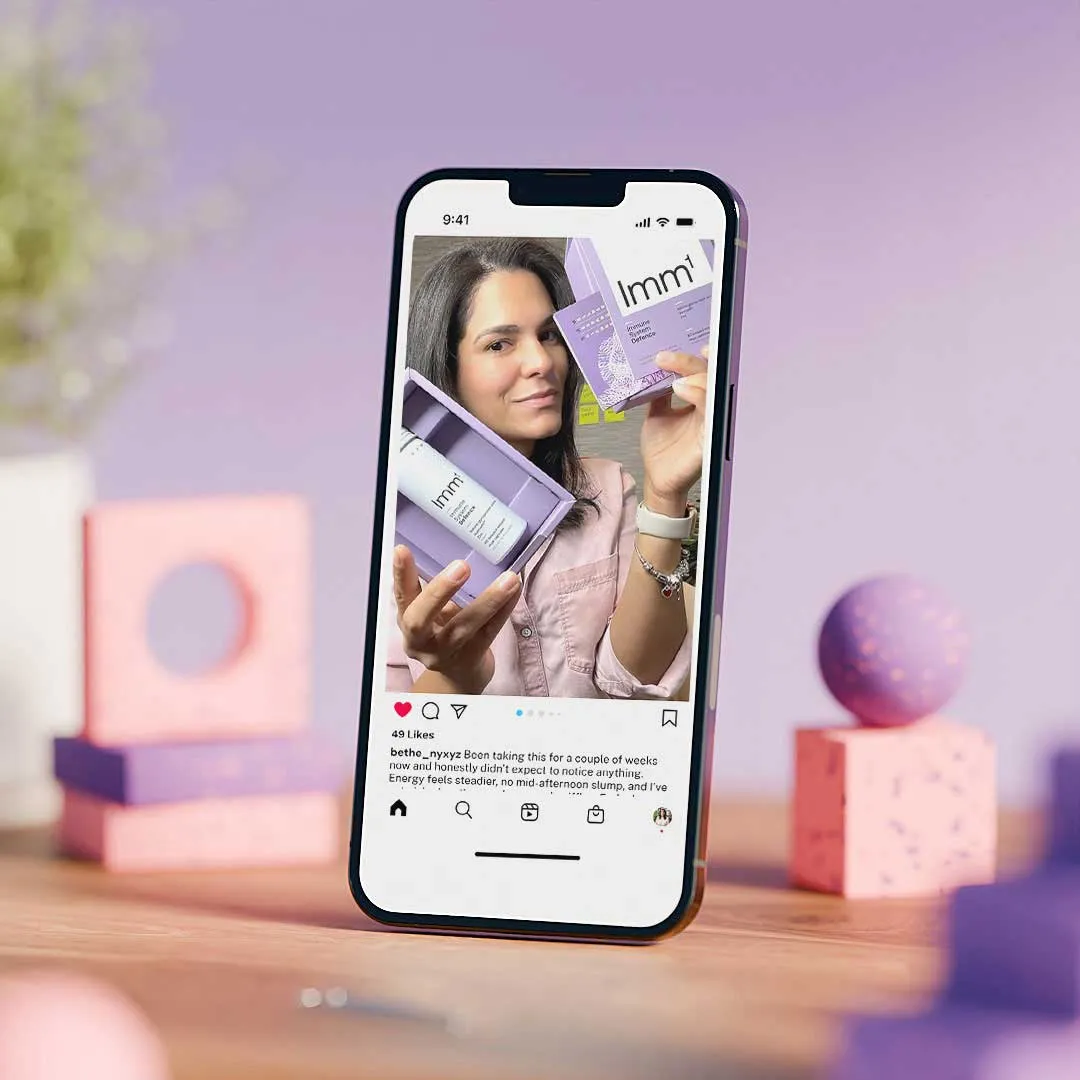 Smartphone displaying an Instagram post of a woman holding a lavender Immune System Defense product box and bottle.