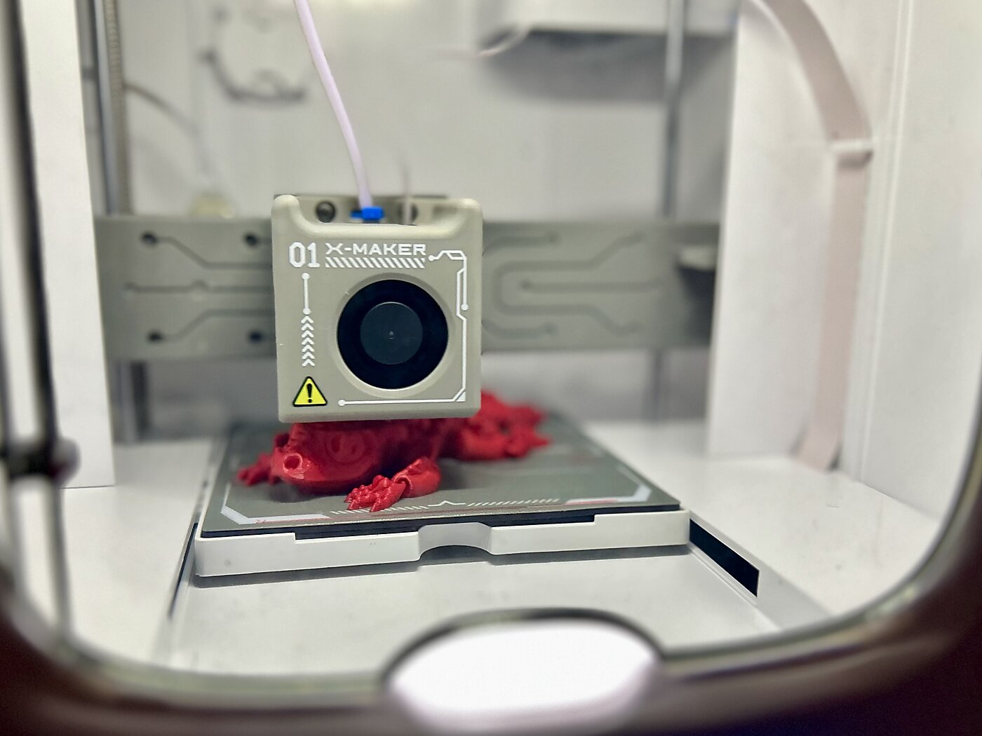 Small 3D printer making a red dragon