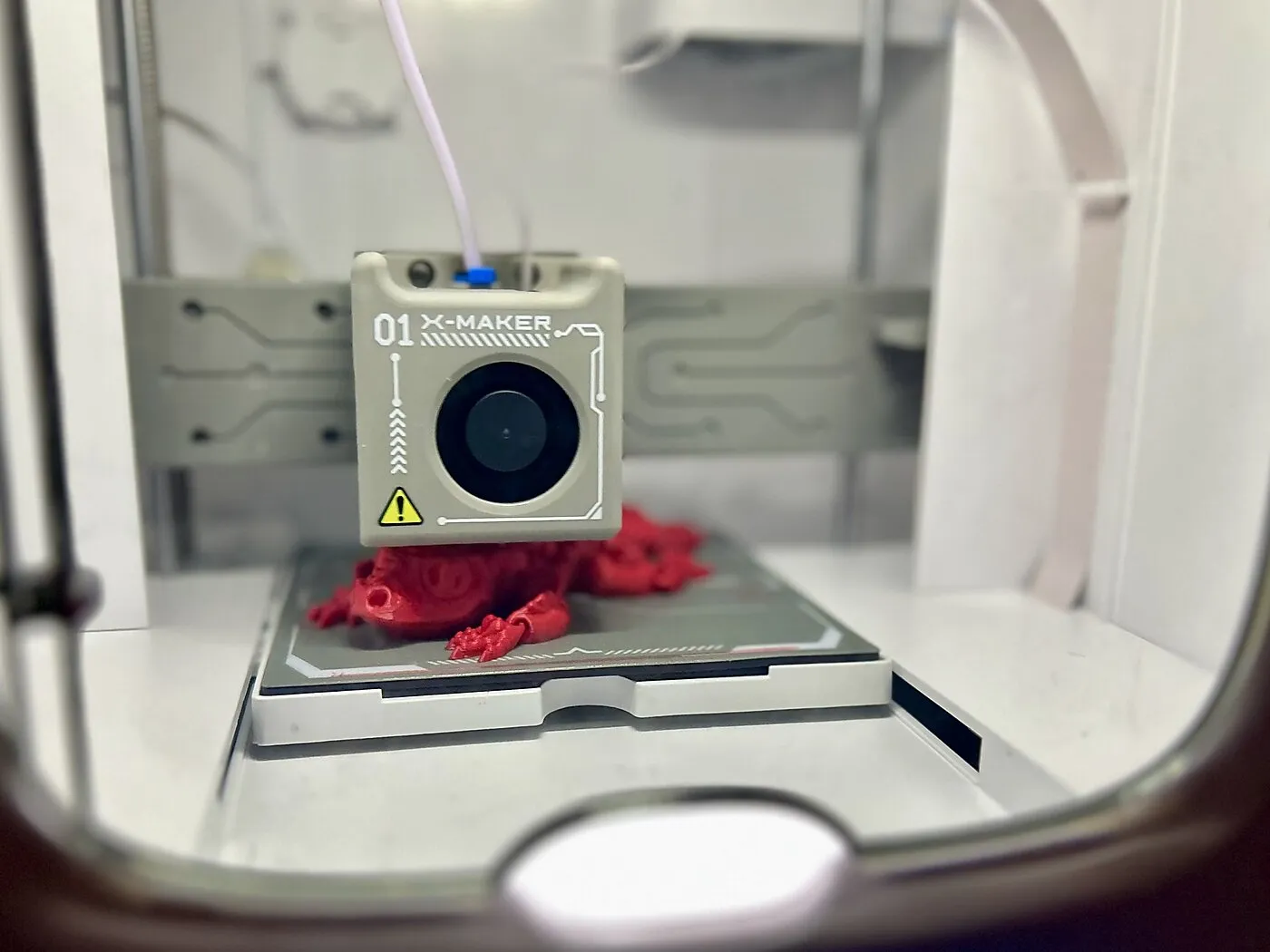 Small 3D printer making a red dragon