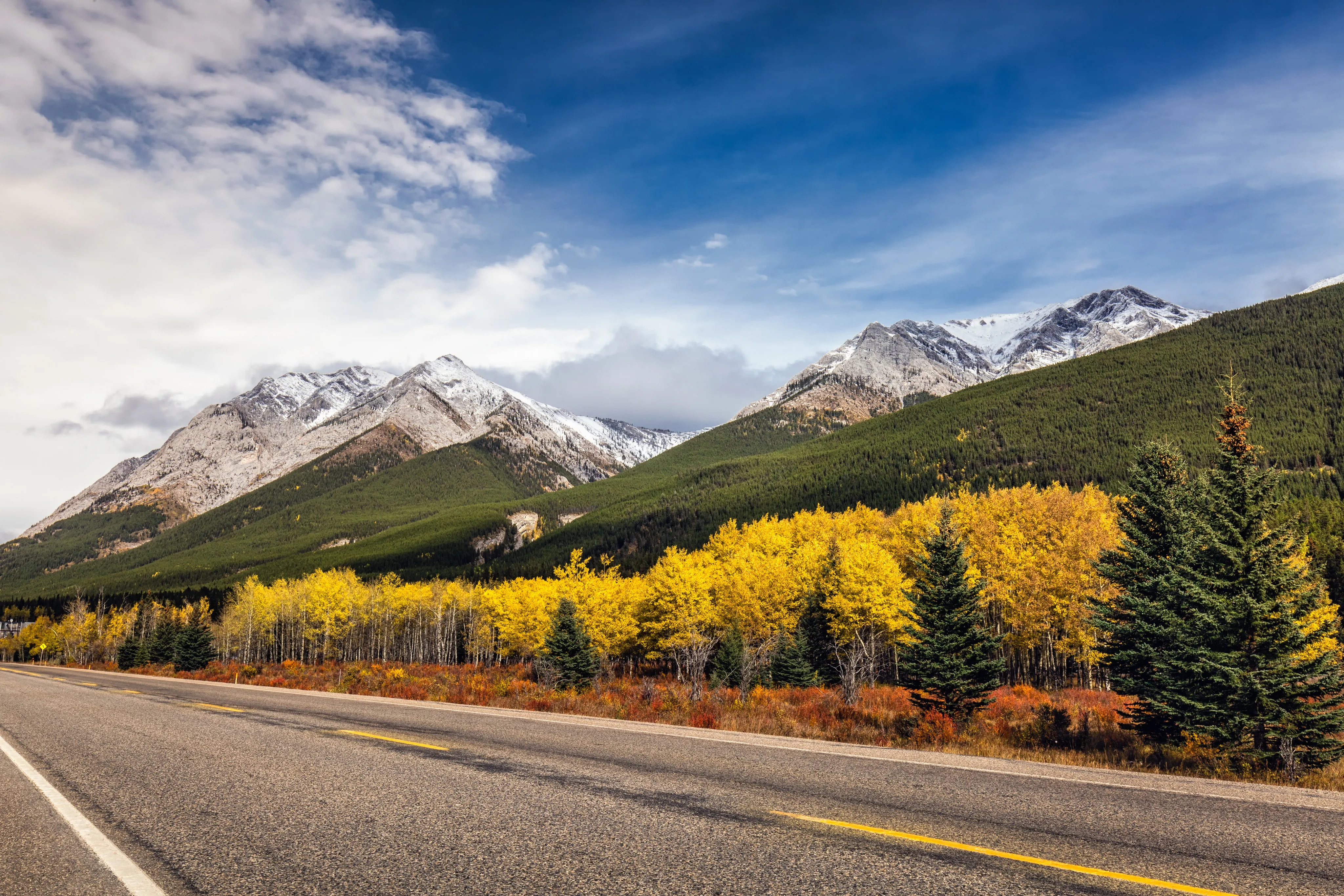 Scenic fall highway in the Colorado Rockies with golden aspens and snow-dusted peaks near Vail and Aspen
