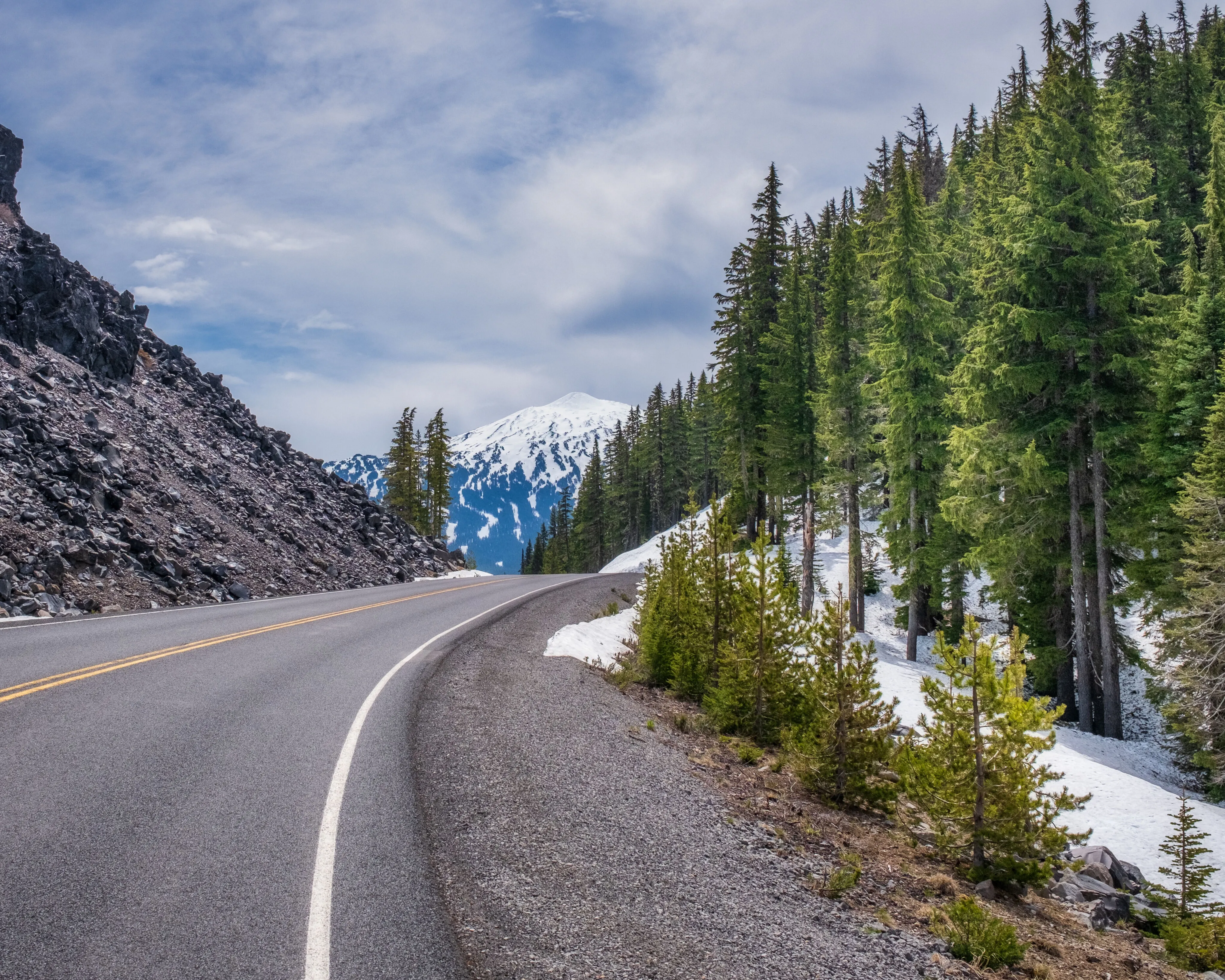 Scenic mountain highway near Aspen, Colorado with snow and pine trees