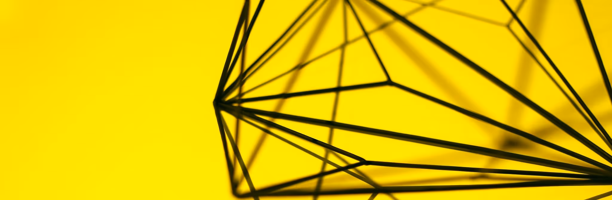 A young woman working in a machine shop. She is looking directly towards the camera, and is surrounded by men.