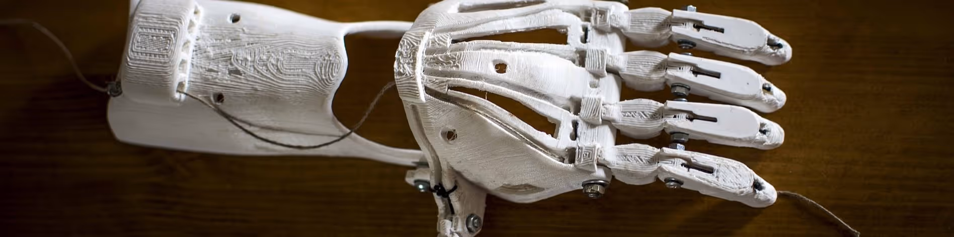 A young woman working in a machine shop. She is looking directly towards the camera, and is surrounded by men.