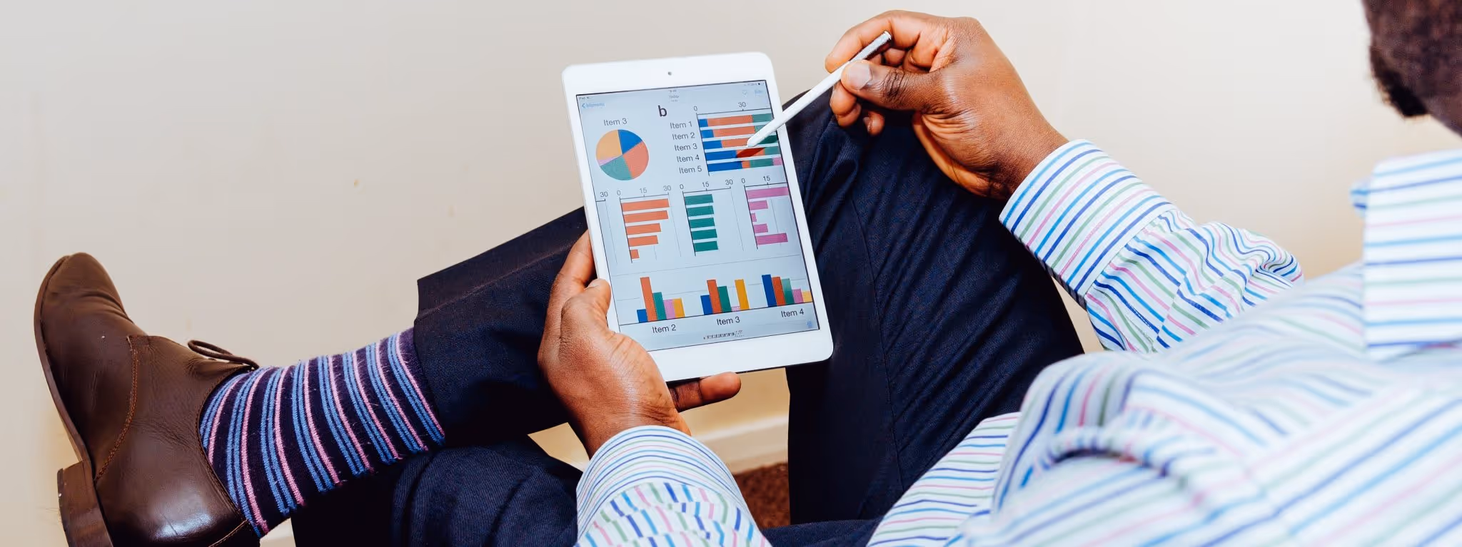 A young woman working in a machine shop. She is looking directly towards the camera, and is surrounded by men.