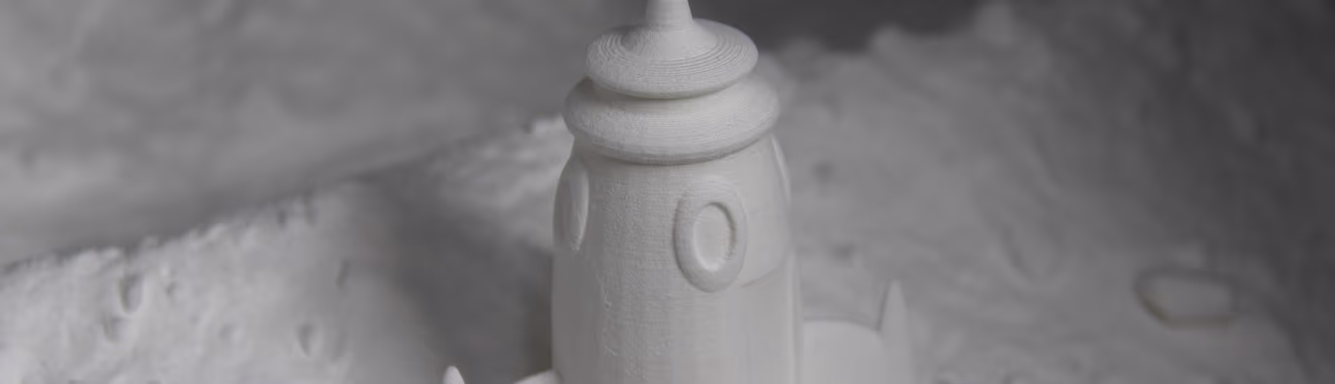 A young woman working in a machine shop. She is looking directly towards the camera, and is surrounded by men.