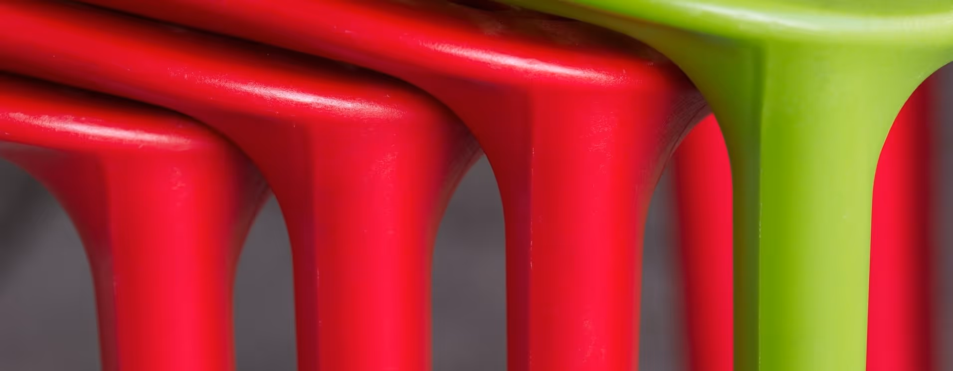 A young woman working in a machine shop. She is looking directly towards the camera, and is surrounded by men.