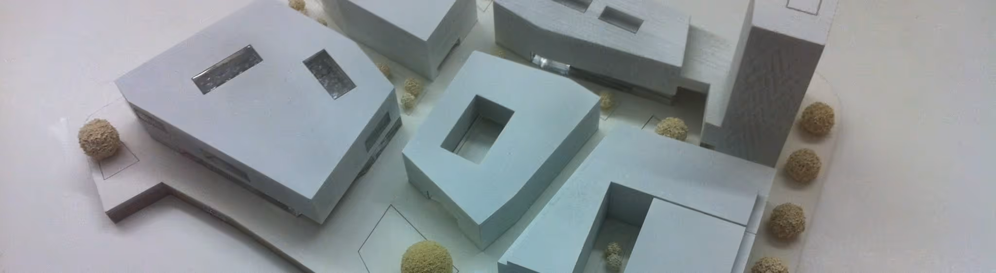 A young woman working in a machine shop. She is looking directly towards the camera, and is surrounded by men.