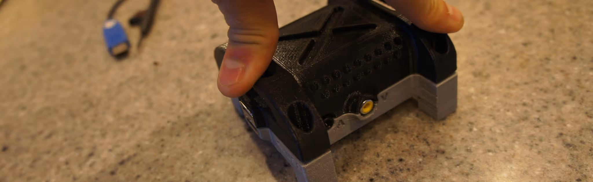 A young woman working in a machine shop. She is looking directly towards the camera, and is surrounded by men.