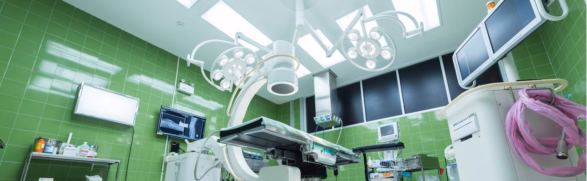 A young woman working in a machine shop. She is looking directly towards the camera, and is surrounded by men.