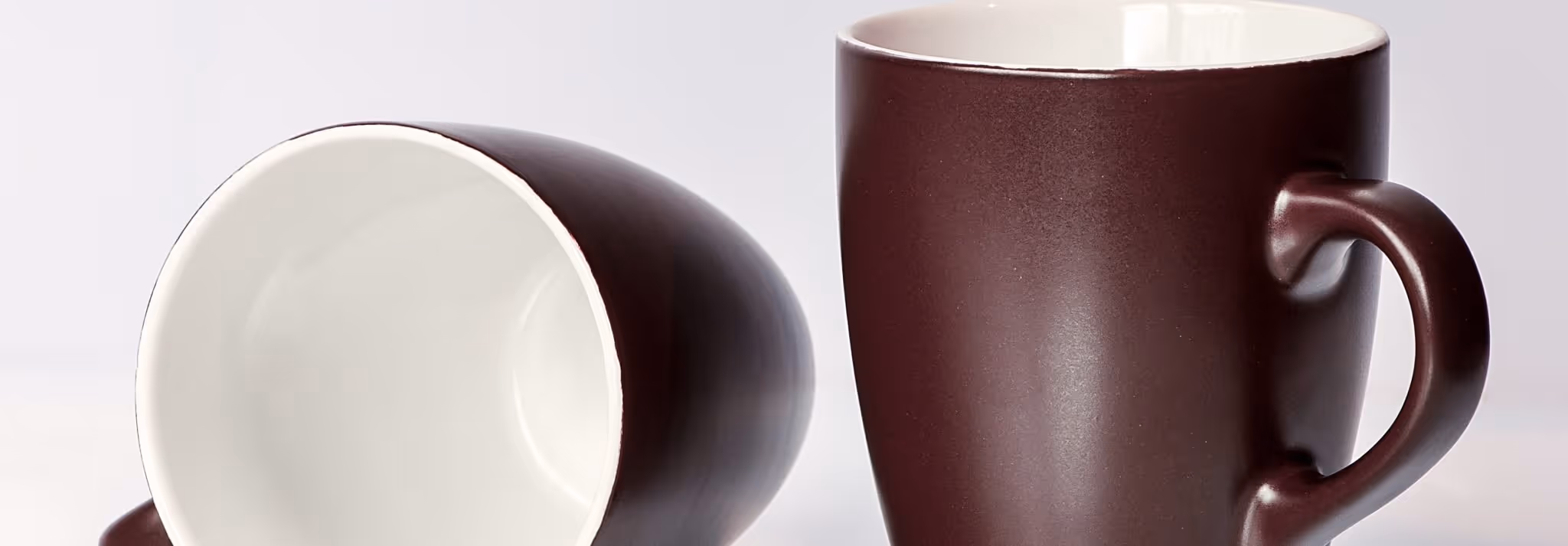 A young woman working in a machine shop. She is looking directly towards the camera, and is surrounded by men.