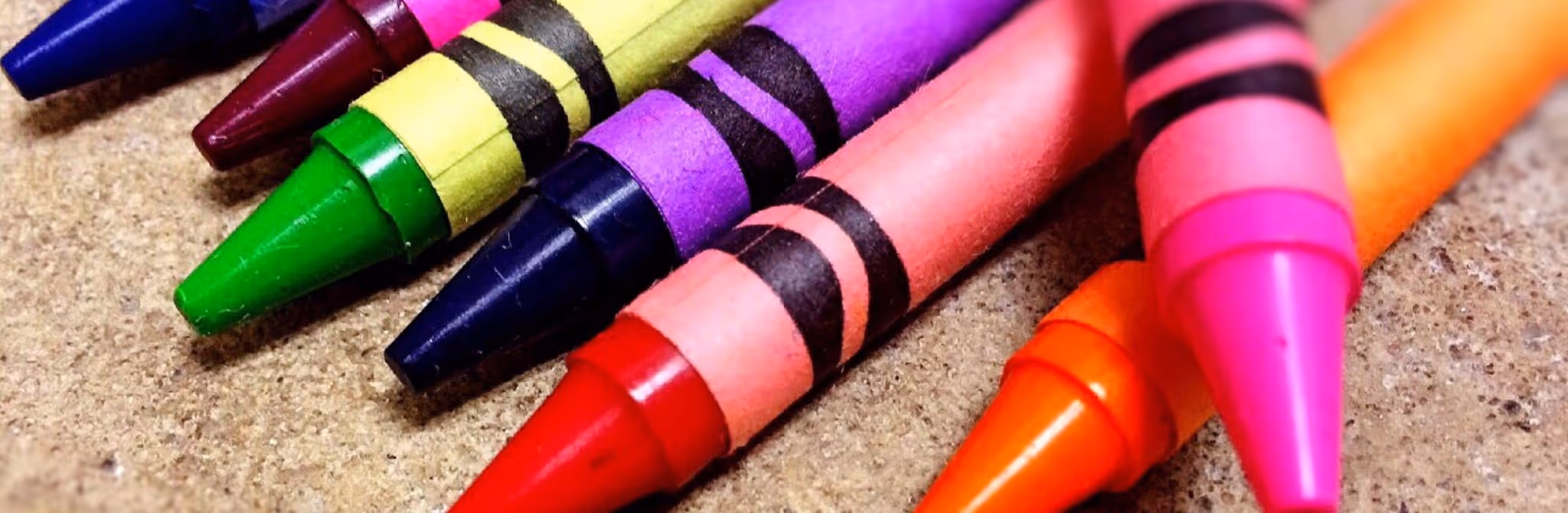 A young woman working in a machine shop. She is looking directly towards the camera, and is surrounded by men.