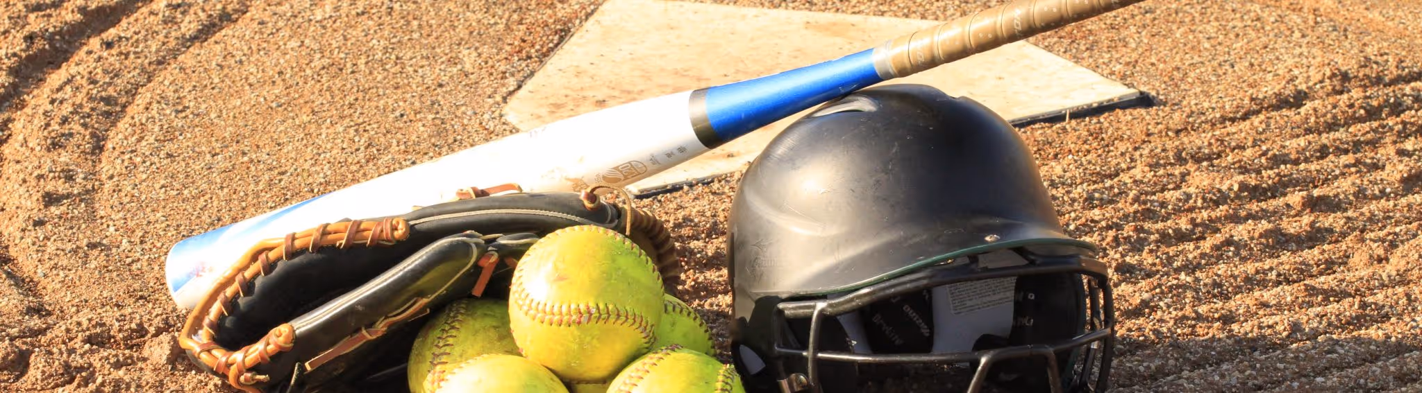 A young woman working in a machine shop. She is looking directly towards the camera, and is surrounded by men.
