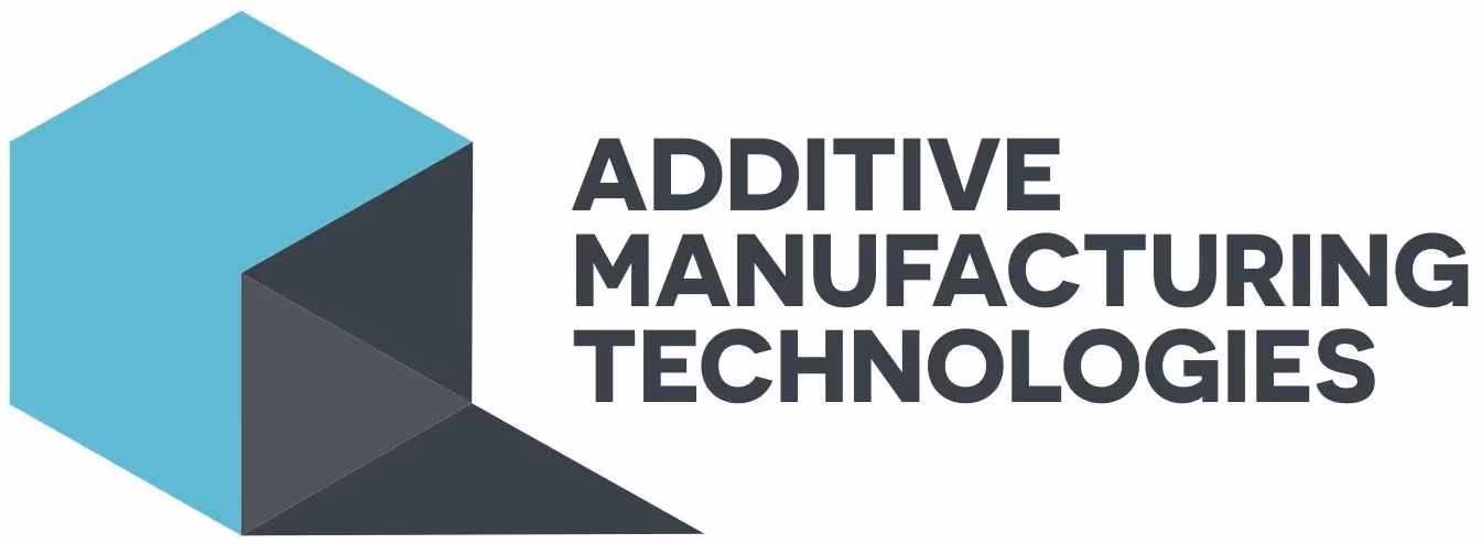 A young woman working in a machine shop. She is looking directly towards the camera, and is surrounded by men.