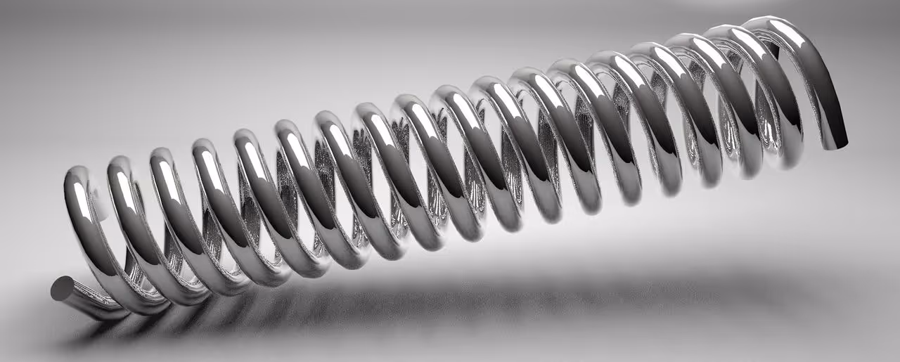 A young woman working in a machine shop. She is looking directly towards the camera, and is surrounded by men.