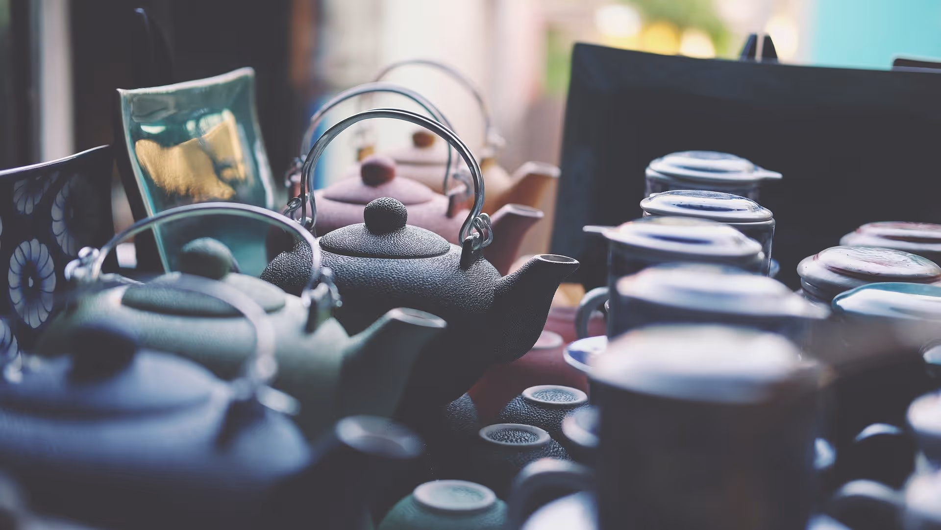 A young woman working in a machine shop. She is looking directly towards the camera, and is surrounded by men.