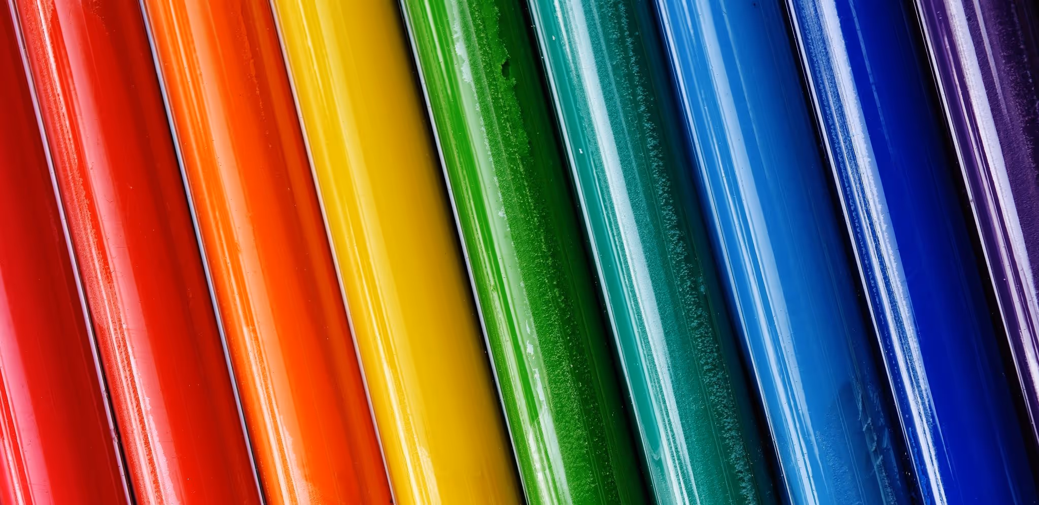 A young woman working in a machine shop. She is looking directly towards the camera, and is surrounded by men.
