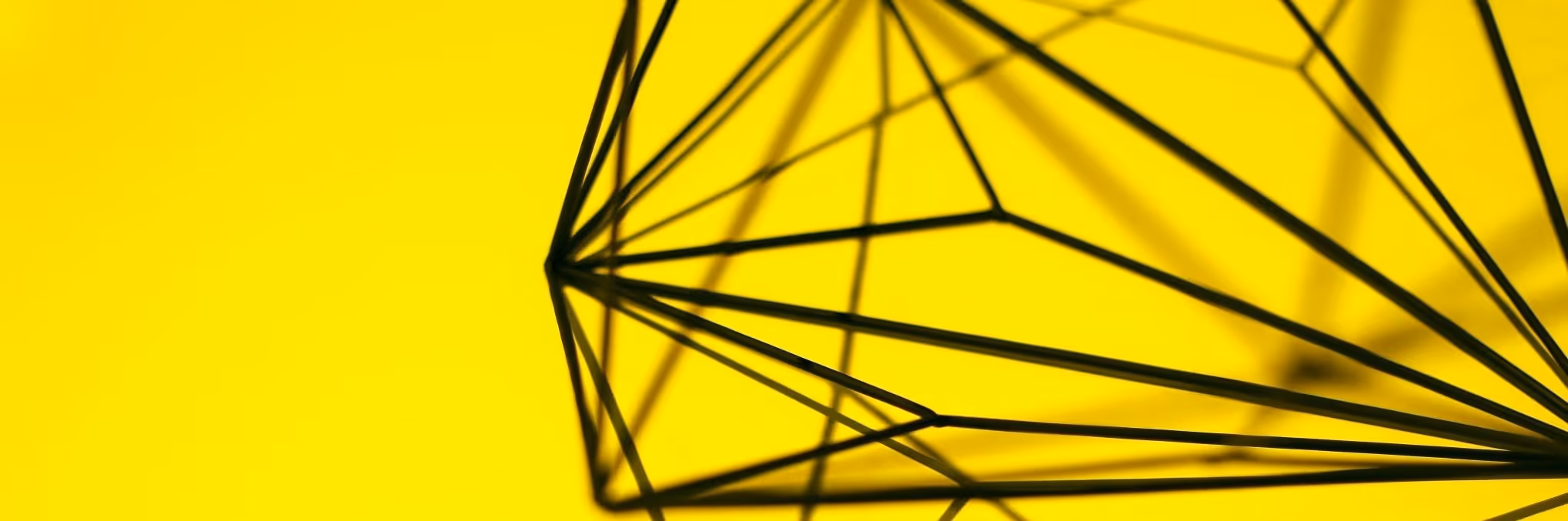 A young woman working in a machine shop. She is looking directly towards the camera, and is surrounded by men.