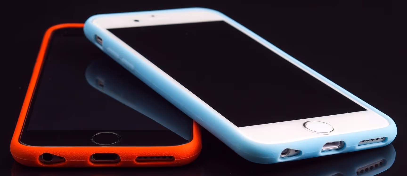 A young woman working in a machine shop. She is looking directly towards the camera, and is surrounded by men.