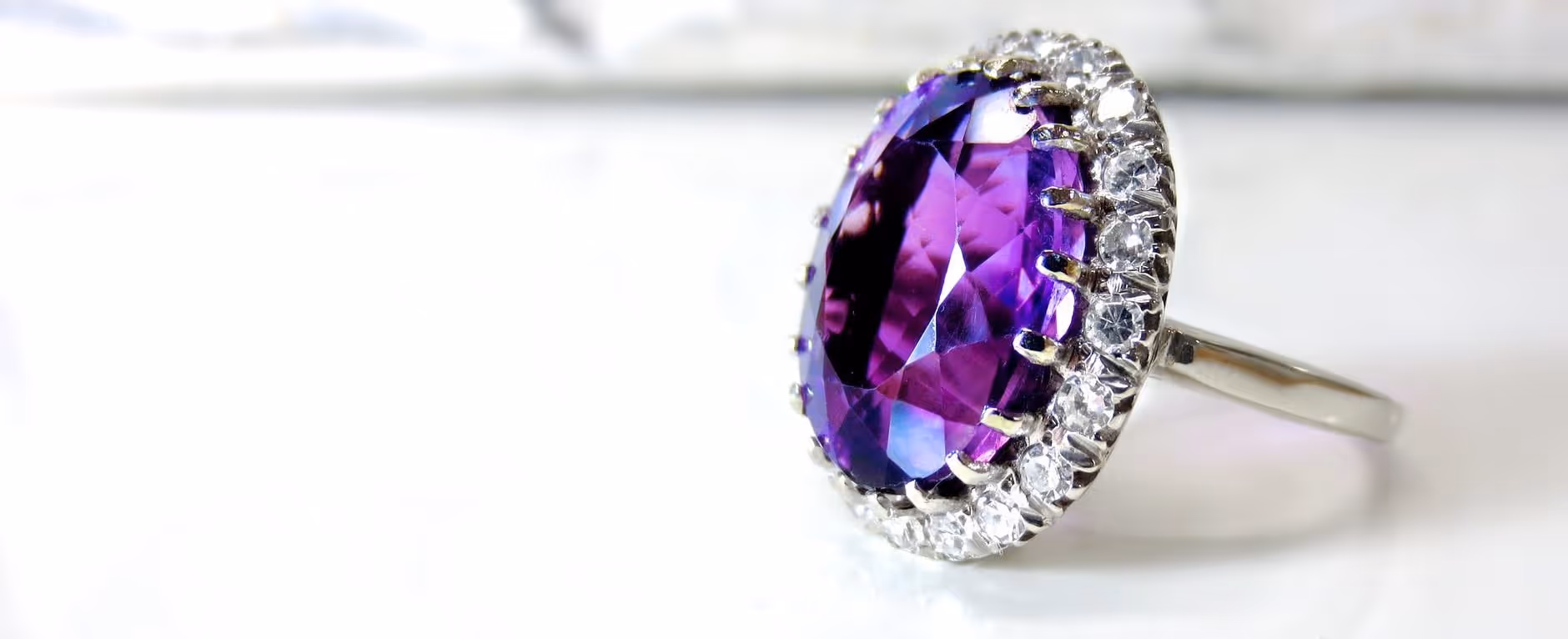 A young woman working in a machine shop. She is looking directly towards the camera, and is surrounded by men.