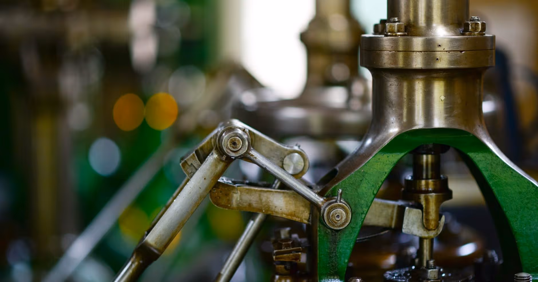 A young woman working in a machine shop. She is looking directly towards the camera, and is surrounded by men.