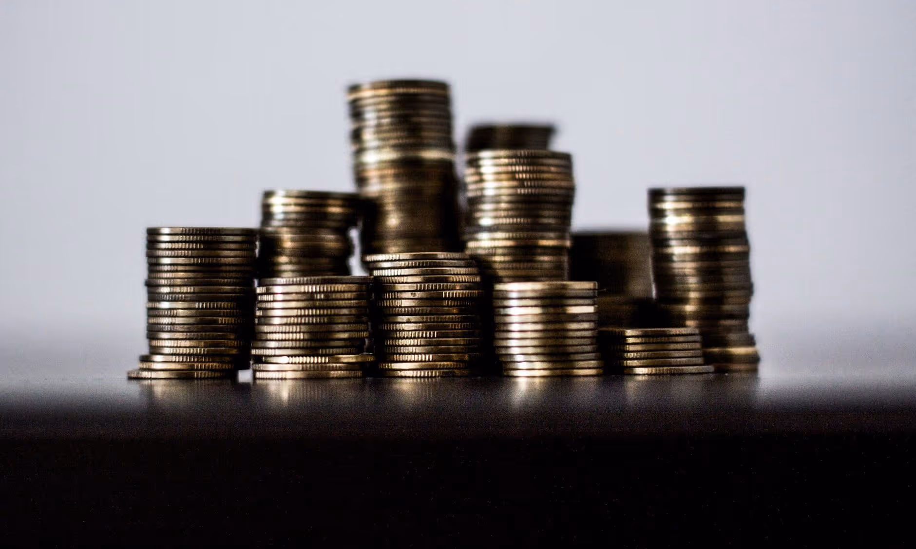 A young woman working in a machine shop. She is looking directly towards the camera, and is surrounded by men.