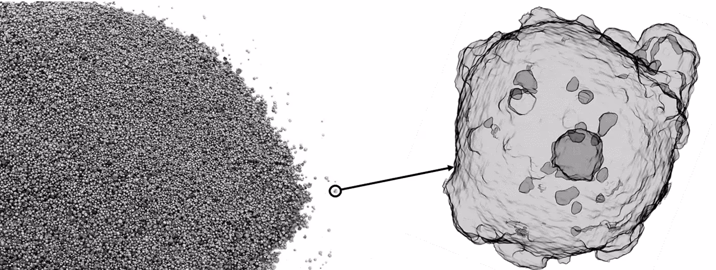 A young woman working in a machine shop. She is looking directly towards the camera, and is surrounded by men.