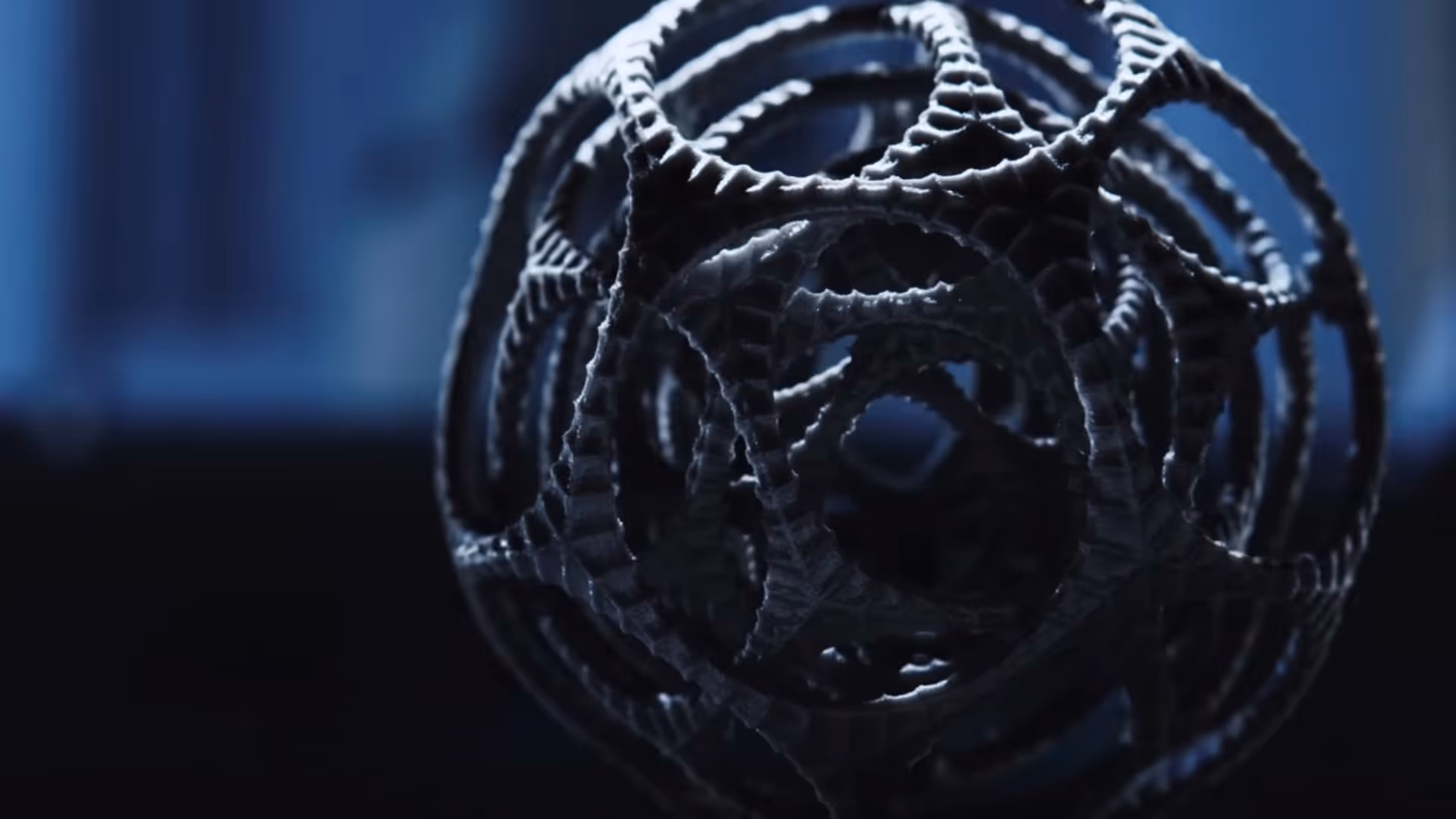 A young woman working in a machine shop. She is looking directly towards the camera, and is surrounded by men.