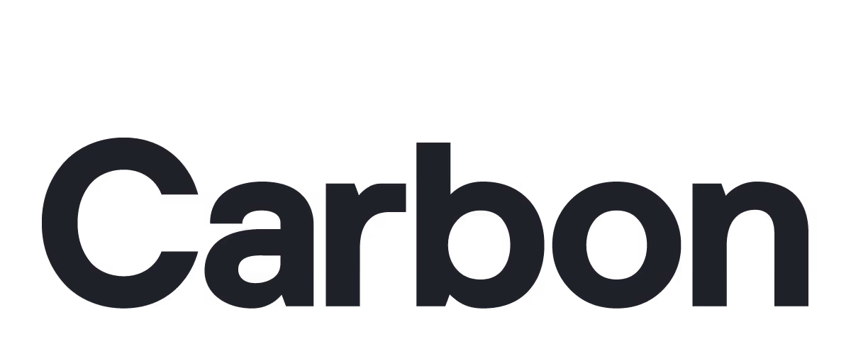 A young woman working in a machine shop. She is looking directly towards the camera, and is surrounded by men.