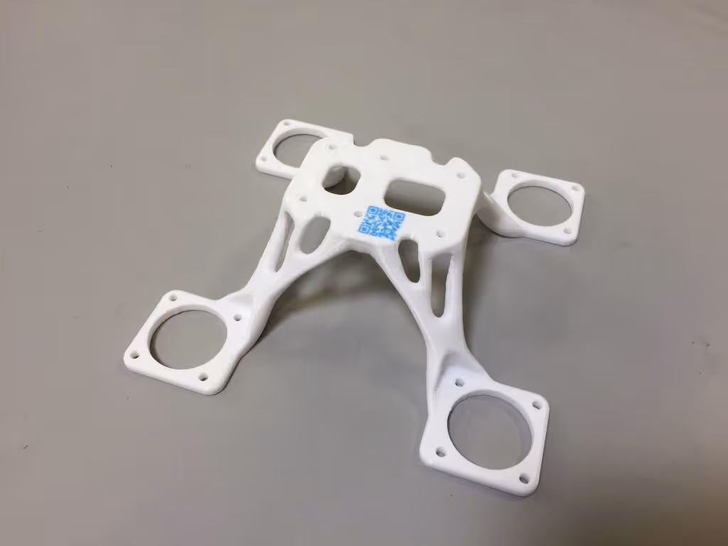 A white 3D printed part with a QR code 