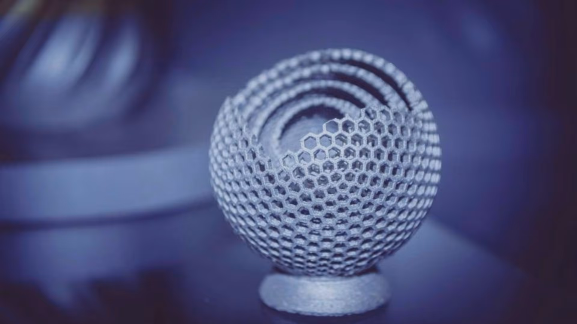 A young woman working in a machine shop. She is looking directly towards the camera, and is surrounded by men.