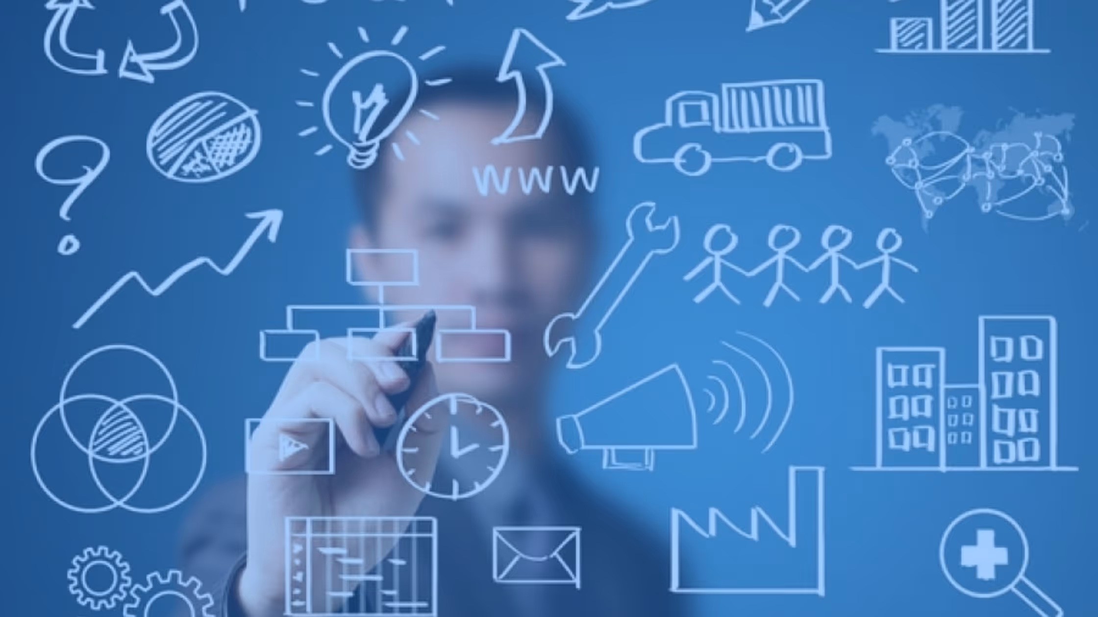 A young woman working in a machine shop. She is looking directly towards the camera, and is surrounded by men.