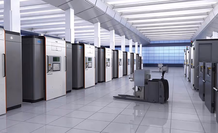 A young woman working in a machine shop. She is looking directly towards the camera, and is surrounded by men.