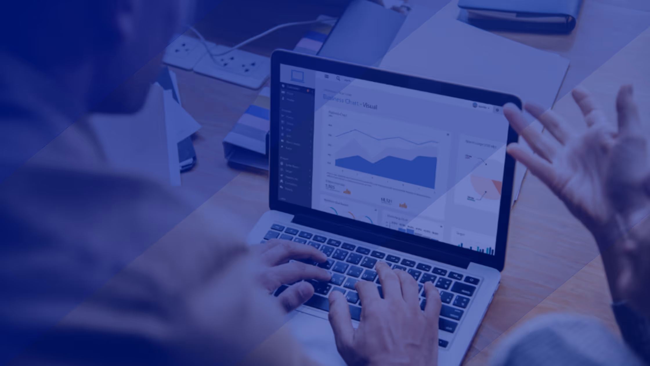 A young woman working in a machine shop. She is looking directly towards the camera, and is surrounded by men.