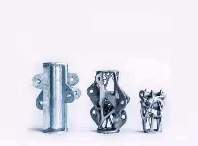 A young woman working in a machine shop. She is looking directly towards the camera, and is surrounded by men.
