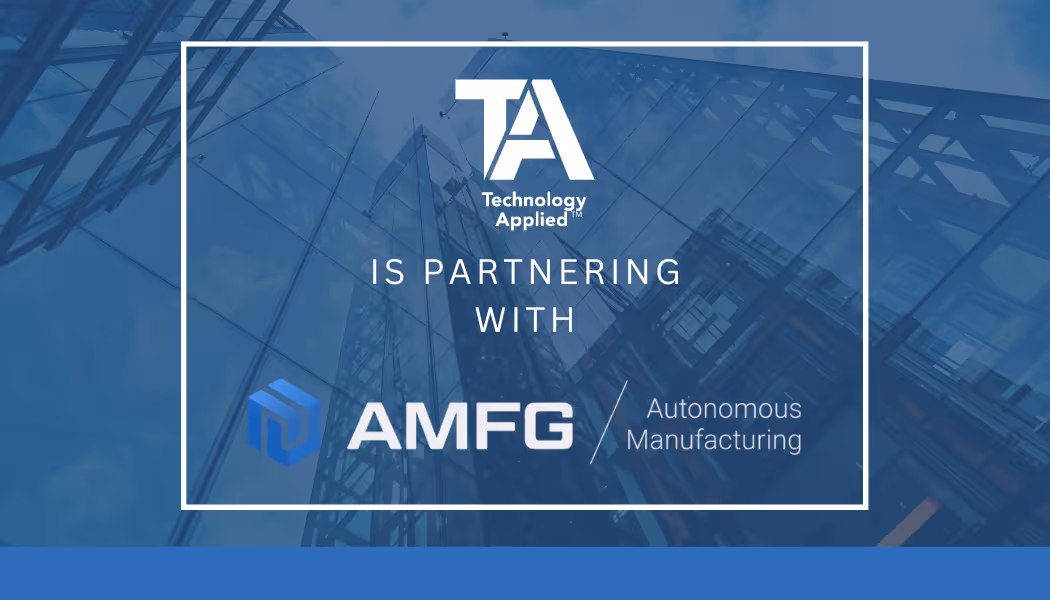 A young woman working in a machine shop. She is looking directly towards the camera, and is surrounded by men.