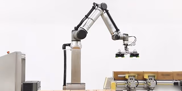 A young woman working in a machine shop. She is looking directly towards the camera, and is surrounded by men.