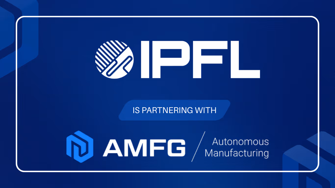 A young woman working in a machine shop. She is looking directly towards the camera, and is surrounded by men.