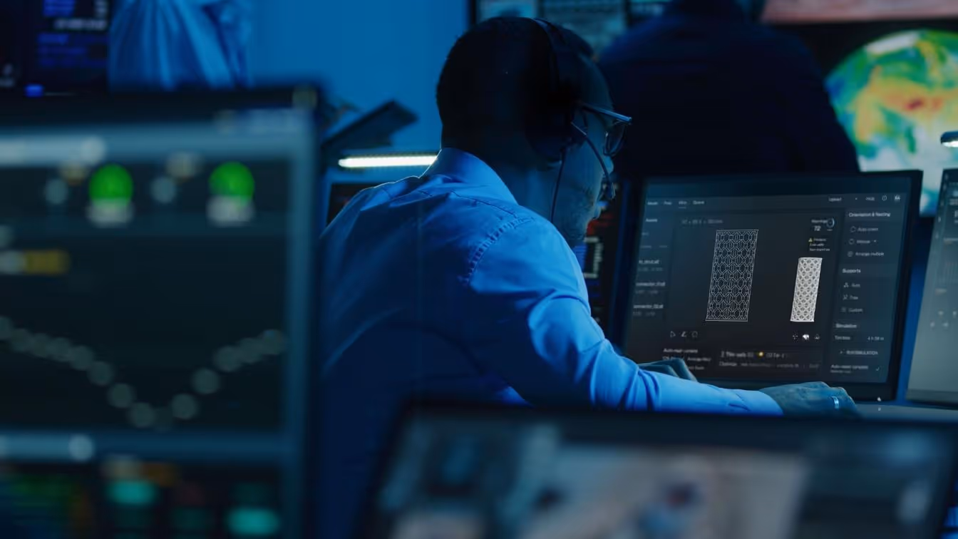 A man in a control room, looking a computer that shows AMFG and Photocentric's technology