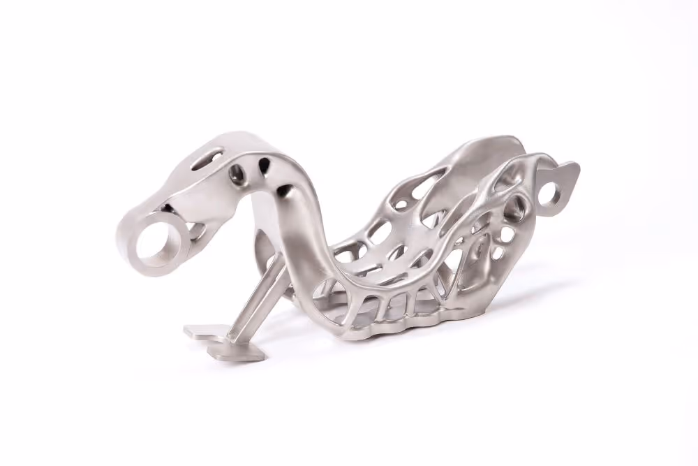 A young woman working in a machine shop. She is looking directly towards the camera, and is surrounded by men.