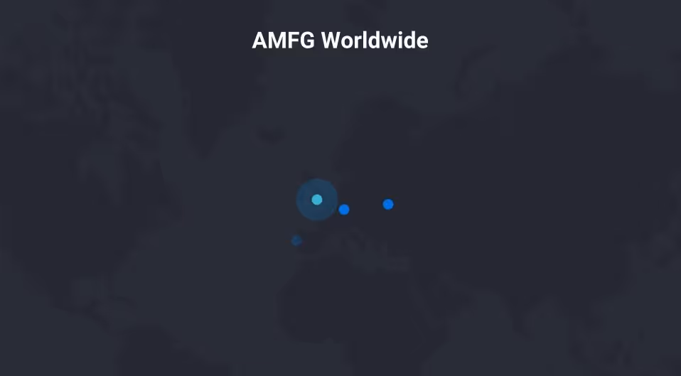 A young woman working in a machine shop. She is looking directly towards the camera, and is surrounded by men.