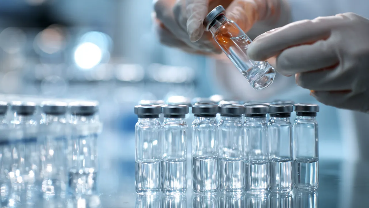 Scientist preparing injectable vials as part of comprehensive drug product development and formulation services.